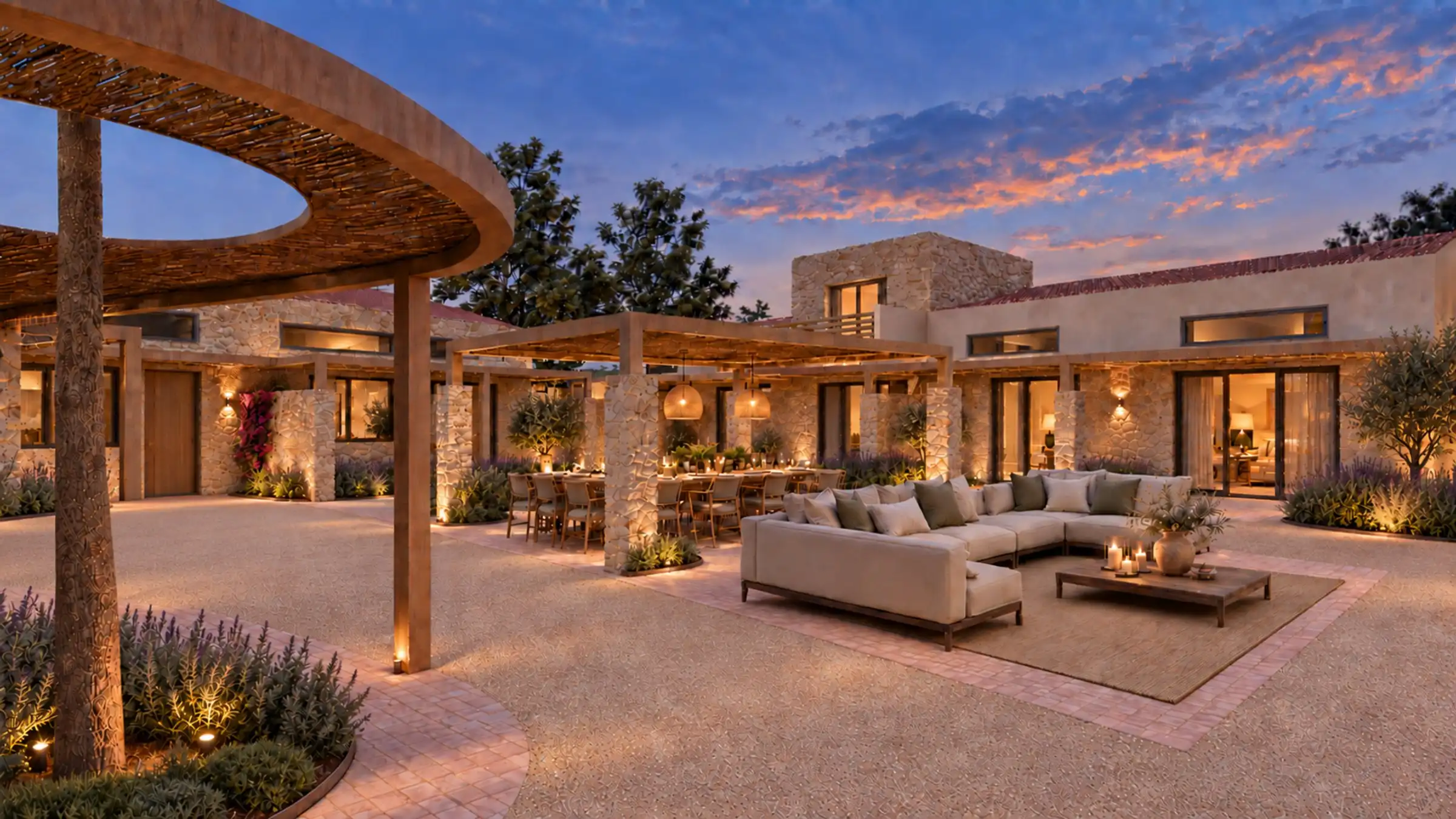 The shared courtyard at dusk, with stone homes, lavender and olive trees