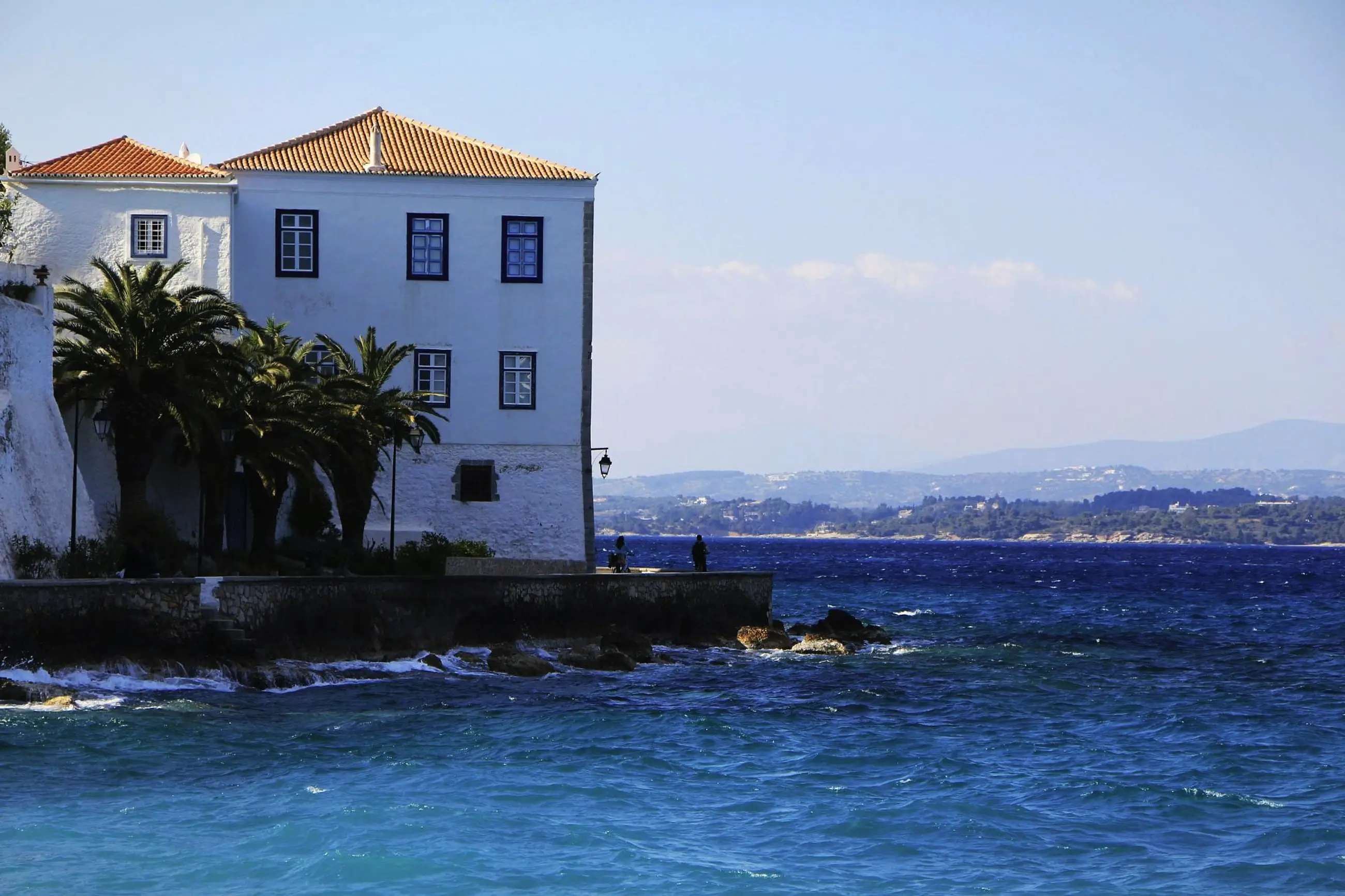 A white mansion with palm trees on the Spetses waterfront